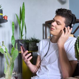 Portrait of teenage boy 16 years old in headphones listening to music