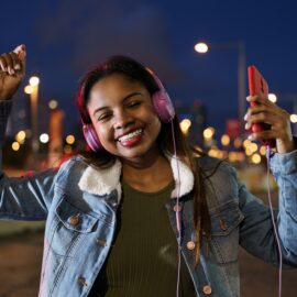 Young African American Latin Woman listening to salsa music on headphones